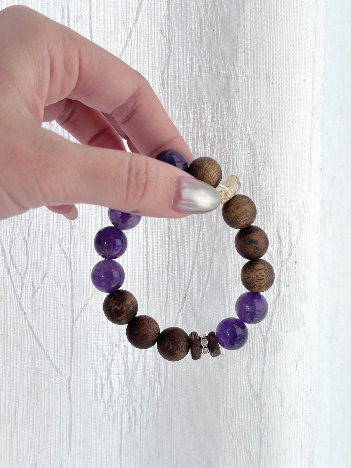 Purple amethyst crystal beads close-up, natural healing bracelet